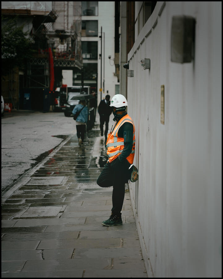 Photo of a worker in high vis taking shelter from the rain