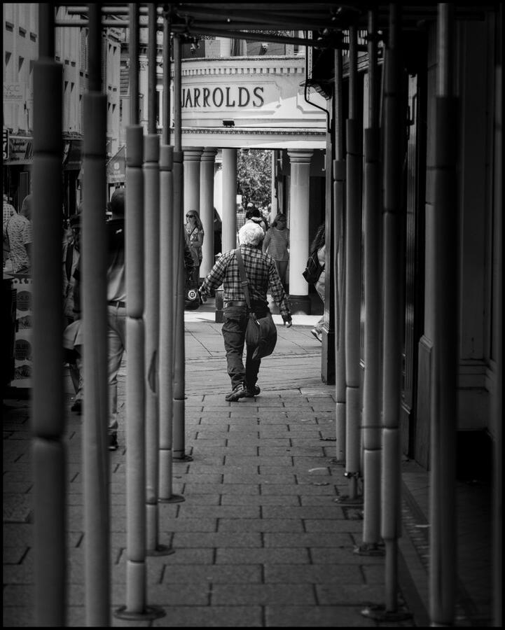 They see me strolling.... Photo of a man walking through some scaffolding